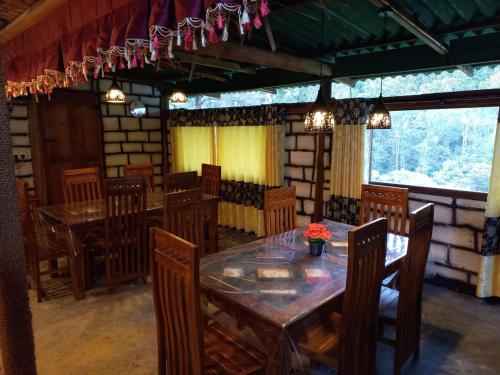 a dining room with a wooden table and chairs at Ohiya Jungle resort in Ohiya