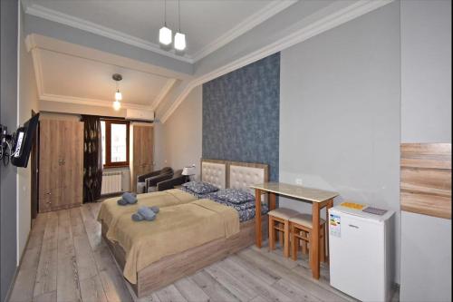 a bedroom with a bed and a table and a desk at Komitas Residence in Yerevan