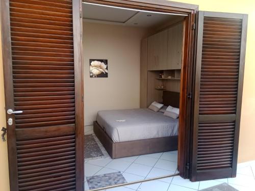 a bedroom with a bed and a door leading into a room at Residenza butterfly IUN R6379 in Villasimius