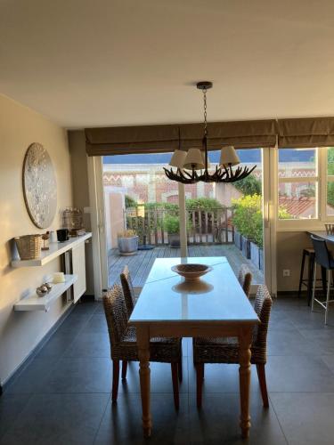 une salle à manger avec une table, des chaises et un lustre dans l'établissement Agréable et spacieuse maison centre ville Saint-Omer, à Saint-Omer