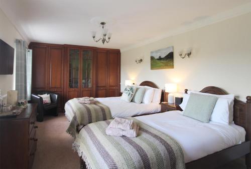 a hotel room with two beds and a chair at Bridge House in Haltwhistle