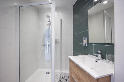 La salle de bains est pourvue d'une douche, d'un lavabo et d'un miroir. dans l'établissement L’Automnal - Centre-Ville - Arrivée Autonome, à Annonay