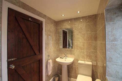 a bathroom with a sink and a toilet and a mirror at Bridge House in Haltwhistle