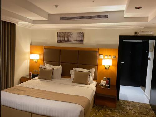 a large bed in a hotel room with two lamps at Al Salam Royal Hotel Suites in Taif