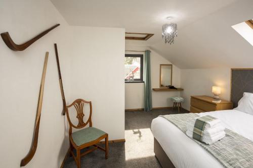 a bedroom with a bed and a chair in a room at Hillside Balcony in Kingussie