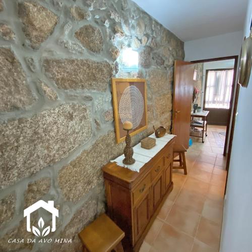 Cette chambre est dotée d'un mur en pierre avec une table et une lampe. dans l'établissement A casa da avó Mina, à Sabugal