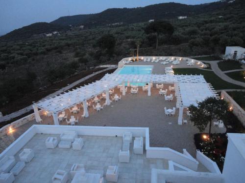 an overhead view of a pool with white tables and chairs at Masseria Santa Teresa in Monopoli