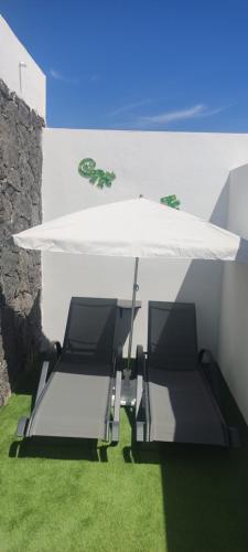 a table and two chairs under a white umbrella at Casita Emma in Playa Blanca