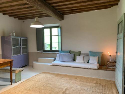 una sala de estar con sofá en una habitación con ventana en Capannacce Organic and Horse Farm, en Rapolano Terme