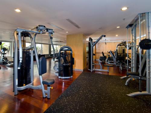 a gym with several tread machines in a room at Novotel Semarang in Semarang