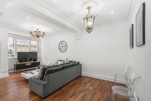 uma sala de estar com um sofá e um relógio na parede em Hububb Luxury Knightsbridge House em Londres
