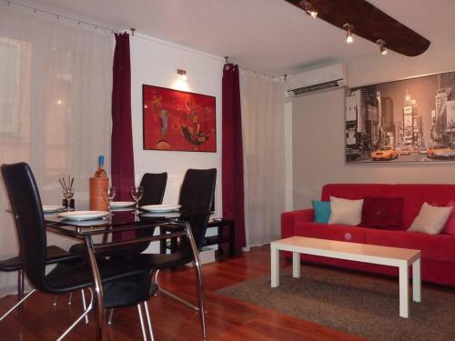 un salon avec une table et un canapé rouge dans l'établissement Vieux Nice 2 pièces Appartement SAN REMO, à Nice