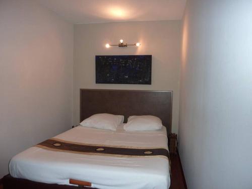 Cette petite chambre comprend un lit avec des draps blancs. dans l'établissement Vieux Nice 2 pièces Appartement SAN REMO, à Nice