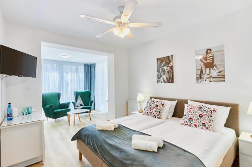 a white bedroom with a bed and a ceiling fan at Villa Astoria in Świnoujście