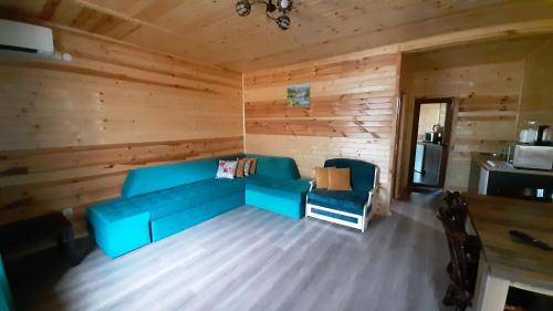 ein Wohnzimmer mit einem blauen Sofa in einer Hütte in der Unterkunft Вила ВлаиДа in Saparewa Banja