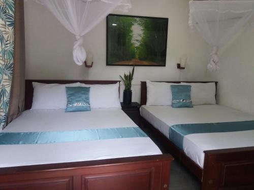 two beds sitting next to each other in a room at Ella green stay in Ella