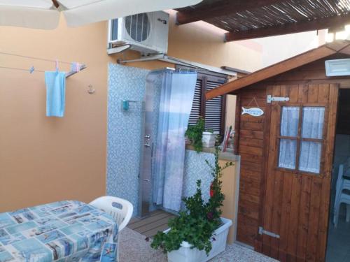 a room with a refrigerator and a table and a door at Residenza butterfly IUN R6379 in Villasimius