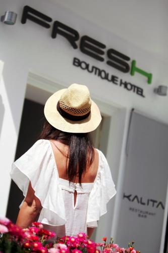 a woman wearing a hat standing in front of a store at Fresh Boutique Hotel in Mýkonos City