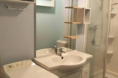 a white bathroom with a sink and a shower at T2 meublé pour curistes, vacanciers et stagiaires in Rochefort