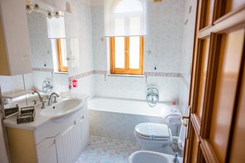 a bathroom with a tub and a sink and a toilet at Villa Bianca in Tramonti