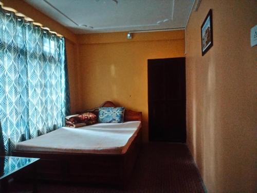 a small room with a bed and a window at Beth Meon Homestay in Darjeeling