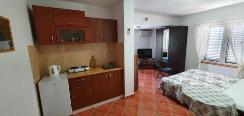 um quarto com uma cama e uma cozinha com uma secretária em Apartments Maxim em Tivat