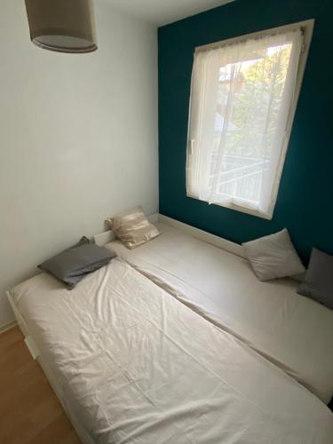 a white bed in a room with a window at Appartement jusqu'à 4 personnes in Luchon