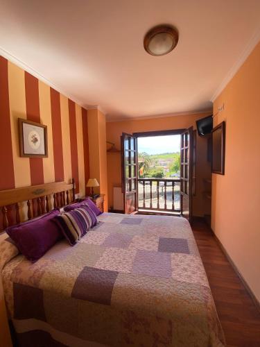 a bedroom with a large bed with a large window at Hostería Miguel Angel in Santillana del Mar