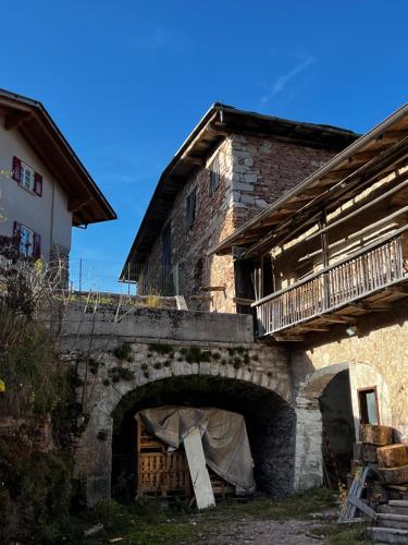 a stone building with a bridge and a house at Casa Nina in Andalo