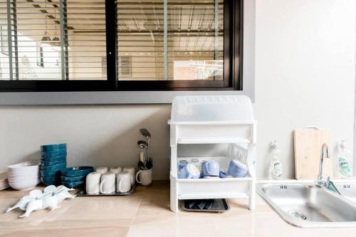 uma cozinha com um lavatório e uma prateleira com copos em Turquoise Sichon Pool Villa em Sichon