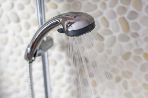 a shower head with water coming out of it at Aquaria Villa in Karterados