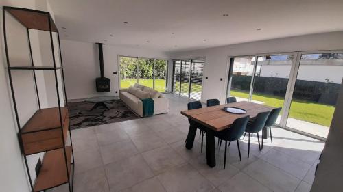 a living room with a wooden table and chairs at L'Aurore du Lac in Sévrier