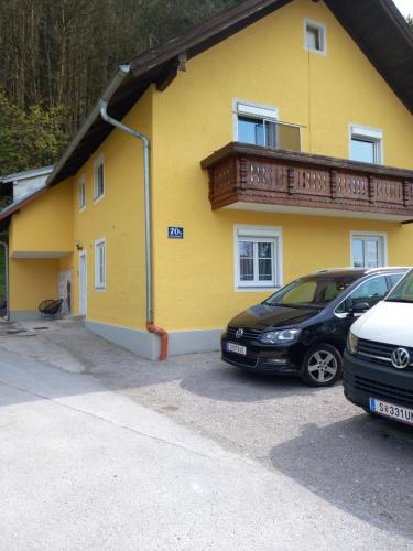 un edificio amarillo con dos coches estacionados frente a él en Wunderschönes 2Zimmer Apartment in Sbg, en Salzburgo