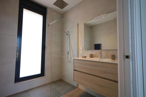 łazienka z prysznicem, umywalką i lustrem w obiekcie Deluxe VILLA LAVANDA Las Colinas DEHESA DE CAMPOAMOR with HEATED POOL w mieście Campoamor