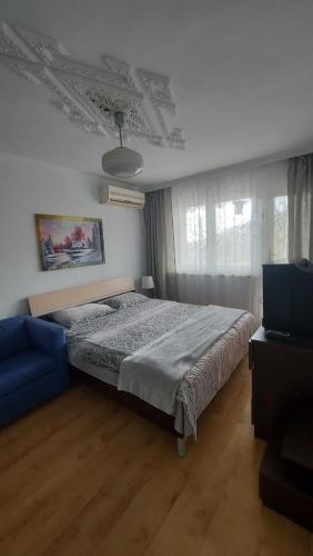 1 dormitorio con 1 cama y 1 sofá azul en Villa Detelina Balchik, en Balchik