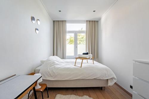 1 dormitorio con 1 cama, escritorio y ventana en Ruime woning in een leuke buurt nabij het centrum en Amberes