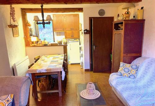 eine Küche und ein Wohnzimmer mit einem Tisch und einem Sofa in der Unterkunft Chalet douillet tout confort in Valdeblore
