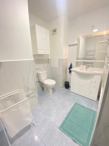 une salle de bain blanche avec des toilettes et un lavabo dans l'établissement Studio Moderne au Victor Hugo, aux Mureaux