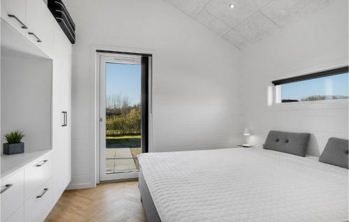 Gorgeous Home In Hadsund With Sauna في Øster Hurup: غرفة نوم بيضاء بها سرير ونافذة