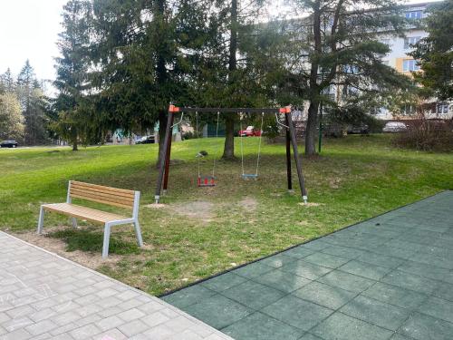a park with a bench and a swing at Ubytovanie pod štítmi Vysokých Tatier in Tatranska Strba