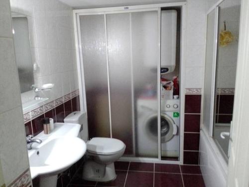 uma casa de banho com um WC, um lavatório e um chuveiro em A cosy flat near sea and subway em Konak