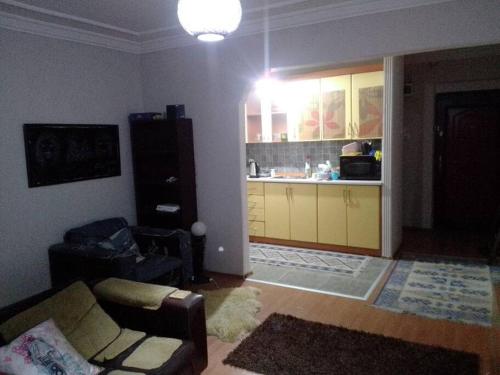 uma sala de estar com um sofá e uma cozinha em A cosy flat near sea and subway em Konak
