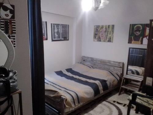 een slaapkamer met een bed en een spiegel bij A cosy flat near sea and subway in Konak