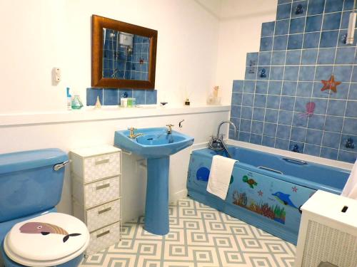 a bathroom with a blue sink and a toilet and a tub at Fab Location 1 bed Apt overlooking Glasgow Green in Glasgow