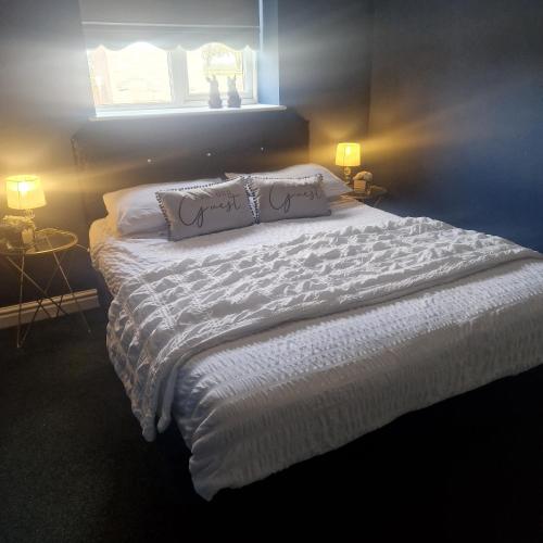 a bedroom with a large white bed with two pillows at Lenox Bed and Breakfast in Hale