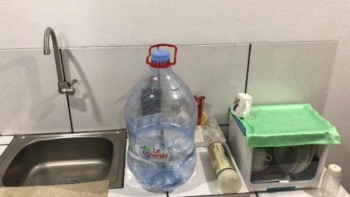 a bottle of water sitting next to a sink at Citisquare apartment for good sleeper in Tenggilismedjojo