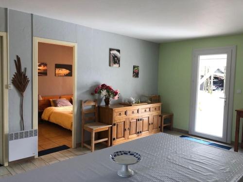 - une chambre avec un lit et une table fleurie dans l'établissement Calme, nature, vitalité. Venez vous ressourcer près de l'océan, à Grayan-et-lʼHôpital