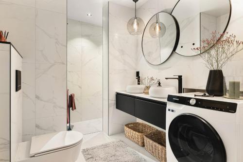 a bathroom with a washing machine and a sink at Bryggen Living in Bergen