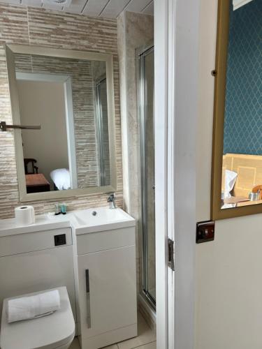 a bathroom with a white sink and a mirror at Earl David Hotel in East Wemyss