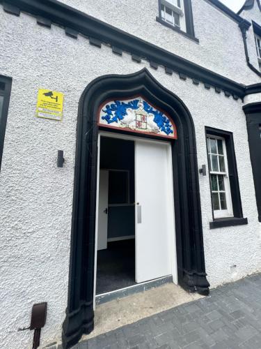 a white building with a white door with a black frame at Earl David Hotel in East Wemyss